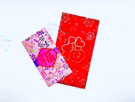 A vibrant red envelope or angpao or angpau or red packet used for gifting money during celebrations with gold floral patterns and a Chinese character for good fortune or prosperity photo