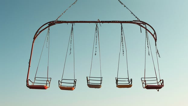 Empty swing set against a clear blue sky photo