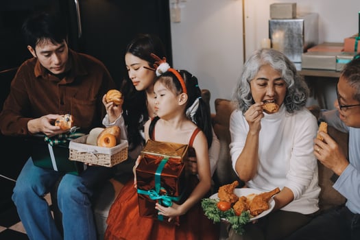 Portrait of Asian family exchanging presents during christmas at home. Attractive happy people holding gift box, celebrate holiday thanksgiving, xmas eve tradition in living room in house together. photo