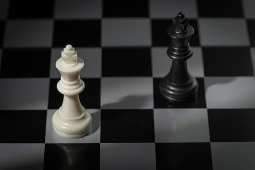 A close-up of a chessboard highlighting the white KING standing out among black pieces, symbolizing strategic thinking, leadership, and decisive planning in overcoming challenges and achieving goals. photo