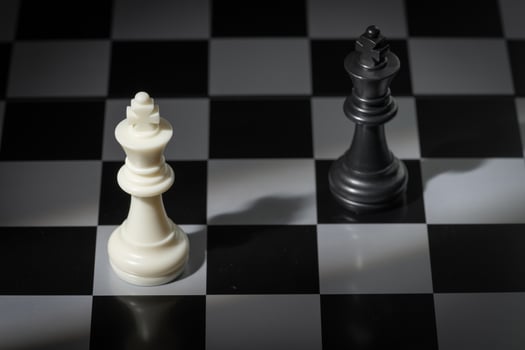A close-up of a chessboard highlighting the white KING standing out among black pieces, symbolizing strategic thinking, leadership, and decisive planning in overcoming challenges and achieving goals. photo