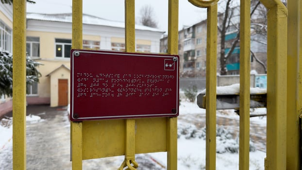 Sign with braille text for blind people at street entrance in winter photo