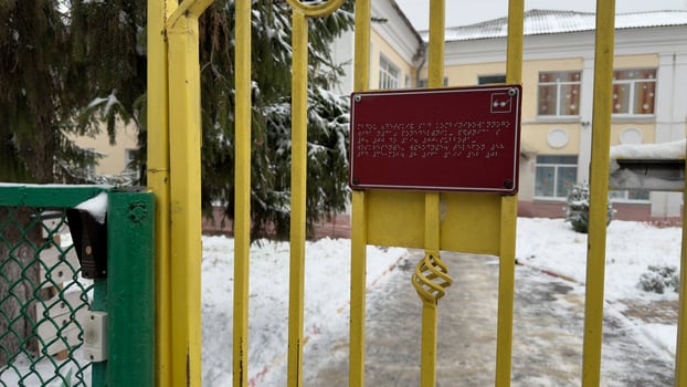Tactile text on sign with information on city street in winter photo