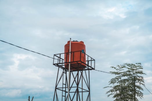 An orange water tower on a hill photo