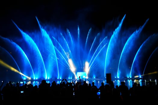 zell am see, Nighttime Crowd of People Enjoying a Vibrant Light and Water Show by the Lake. A Multitude of Colors and Patterns Dance Across the Water Screen, Creating a Mesmerizing Display. photo