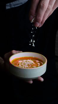 Crafting a delicious bowl of soup with fresh toppings in cozy kitchen photo