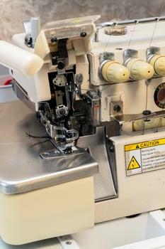Sewing machine for creating seams in fabric at a workshop photo