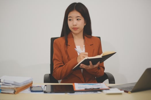A driven and dedicated young professional showcases her efficiency and attention to detail as she works diligently on her laptop photo