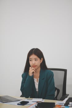 Asian Business woman using calculator and laptop for doing math finance on an office desk, tax, report, accounting, statistics, and analytical research concept photo
