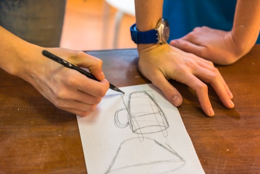 woman hands drawing a draft of a future clay cup photo