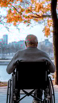 An elderly man in a wheelchair looking out over a city photo