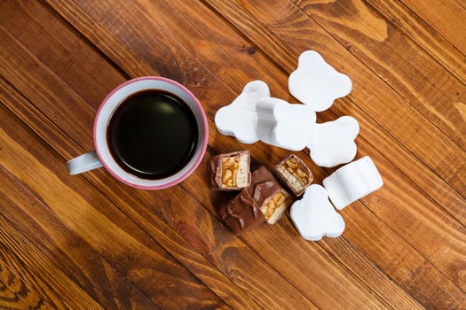 white cup of black coffee, chocolate with nuts on a wooden board with marshmallows photo