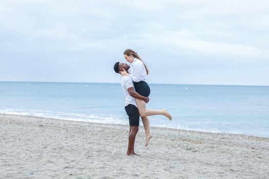 Couple enjoying a joyful moment together on Zapillo beach in Almeria, Spain during a cloudy afternoon photo