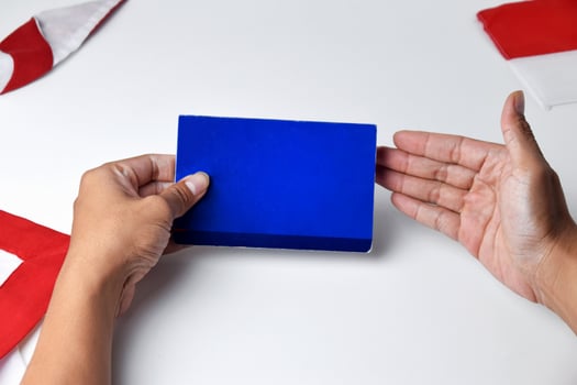 A person holds and shows a blue savings account book photo