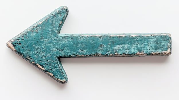 A weathered teal arrow sign directs viewers to the left against a light background, suggesting navigation photo