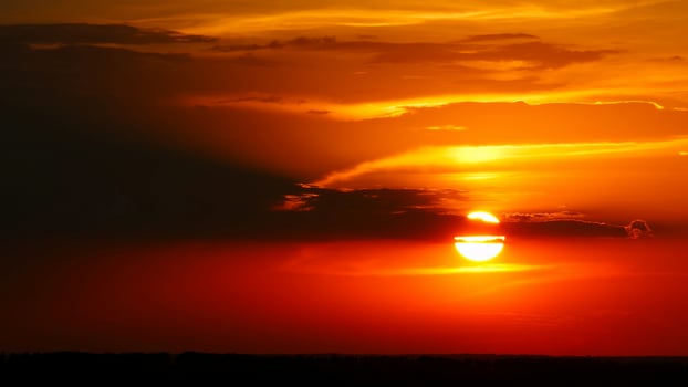 Dramatic red sunrise on dark cloudy sky photo