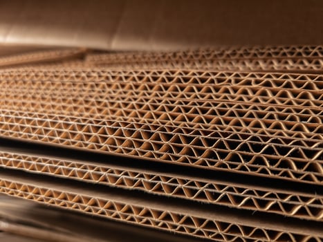 Close-up view of stacked corrugated cardboard layers, showcasing the intricate wave structure and texture, ideal for concepts like packaging, recycling, industry, and material design photo