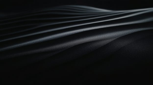 Soft contours of dark sand create elegant forms against subtle lighting photo