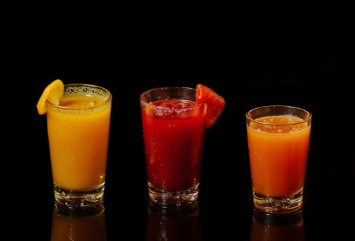 Three glasses of different colored drinks with fruit slices in them photo