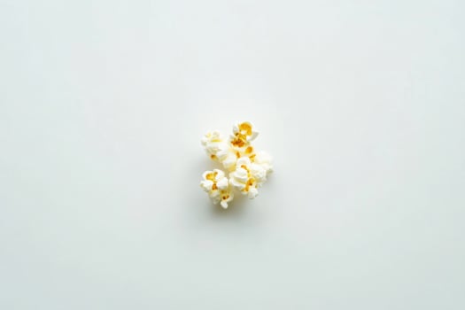 A Small Cluster Of Popcorn Kernels On White photo