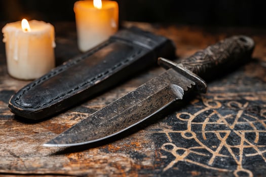 Mystical ritual knife and candles on occult symbols photo