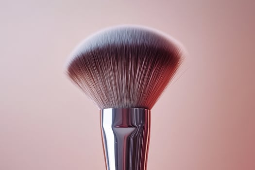 A Closeup of a Powder Brush Against a Soft Pink Background photo