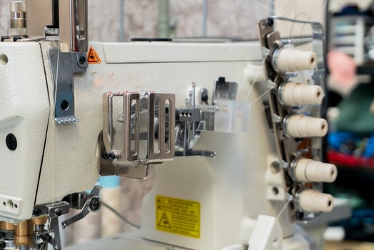 Sewing machine in a workshop with spools and tools visible photo