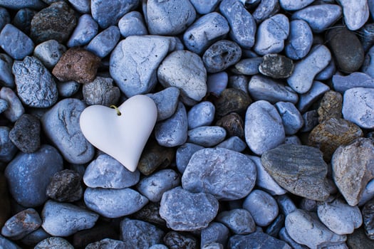 A figurine of a stone heart lies among the stones photo
