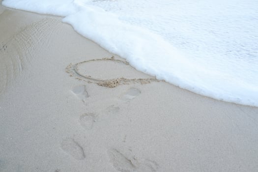 Heart drawn on the beach sand photo