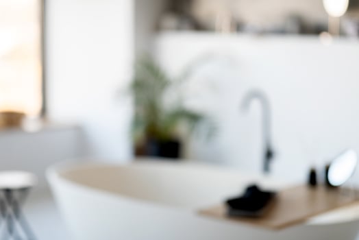 A spacious and bright modern bathroom showcases a freestanding tub, a stylish sink, and plants providing a touch of nature. The atmosphere is serene, perfect for relaxation. photo