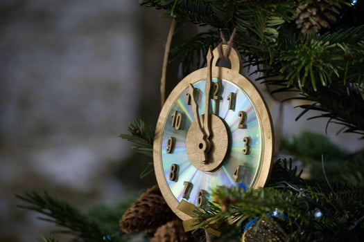 Decorative Clock Ornament Hanging on a Christmas Tree Branch in the Evening Sun photo