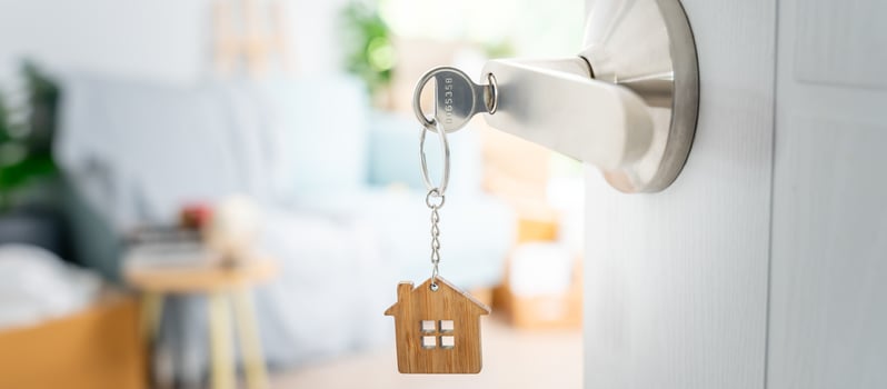 Moving house, relocation. The key was inserted into the door of the new house, inside the room was a cardboard box containing personal belongings and furniture. move in the apartment or condominium photo