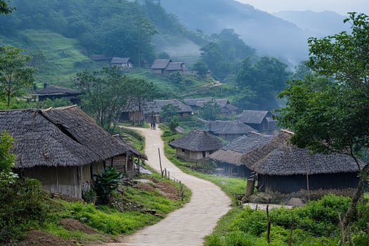 Misty mountain village with thatched roof houses and winding road. photo