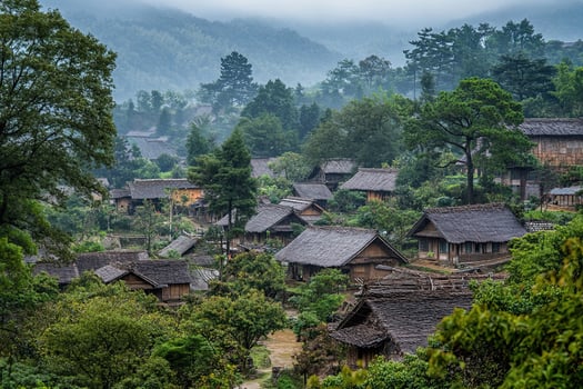 Misty mountain village with traditional houses nestled amongst lush green trees. photo
