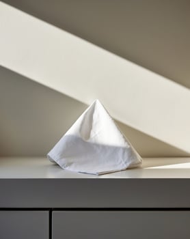 A folded white napkin sitting on top of a table photo