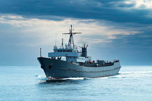 Cargo ship navigating through calm waters under cloudy skies. photo