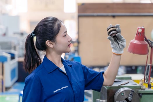 Closeup Asian woman technician engineer hold and looking check example small gear photo