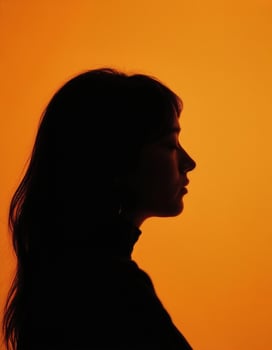 Profile Silhouette of a Woman Against Orange Background photo
