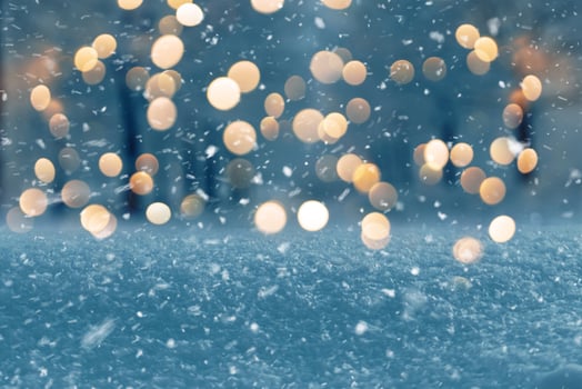 Amazing winter evening with snow and park with golden lights bokeh. New Year and Christmas, winter holiday background. magic winter weather photo