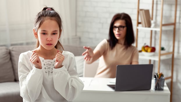Lockdown family problems concept. Mother scolding upset daughter for hindering her online work at home photo