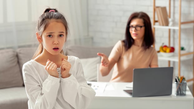 Scared teen girl feeling lonely and neglected, being scolded by her angry tired working mother at home, free space. Young woman having online job during covid-19 lockdown, having no time for her kid photo