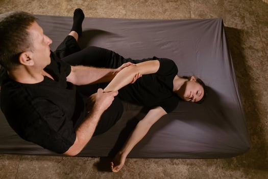 Girl in Thai massage session from therapist in massage room . Traditional Asian stretching therapy photo