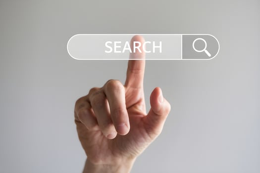 Hand poised over virtual search button, suggesting action in online exploration photo