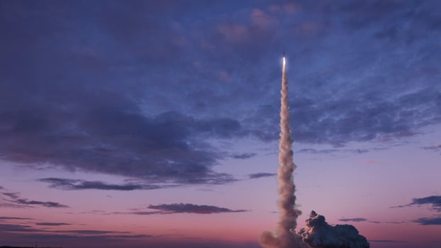 Space rocket with smoke and blast will successfully take off into the pink evening sky with clouds. Space mission and successful launch. Rocket lift off photo