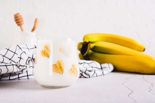 Alternative lactose free banana milk in a glass on the table photo