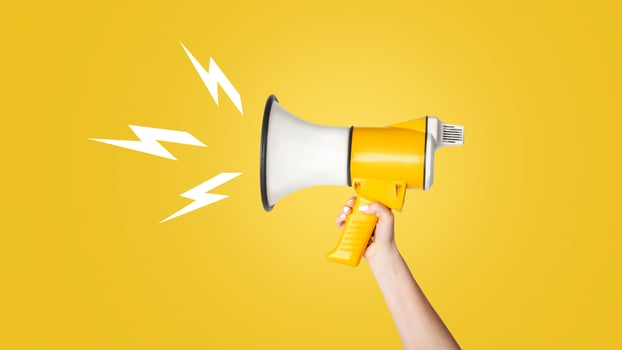 Cropped view of young girl holding megaphone on white background, copy space. Panorama photo