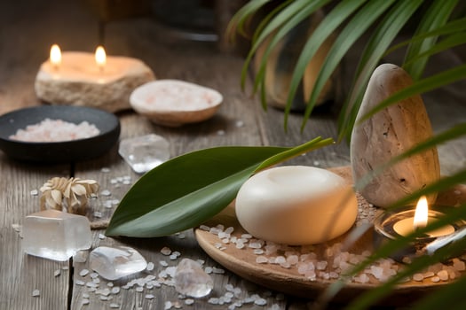 Green leaf with soap, salt crystals, and candle evoke calm spa vibes photo