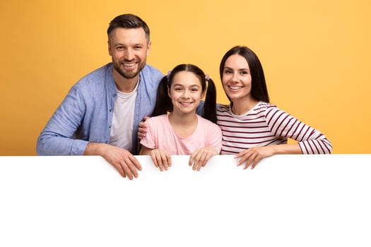 A mother, father, and their teenage daughter smile brightly while leaning on a blank white surface. The cheerful setting emphasizes their connection and warmth, showcasing a loving family bond. photo