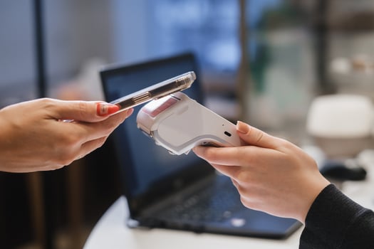A customer uses his phone to pay through a terminal . Concept of cashless technologies and money transfers photo