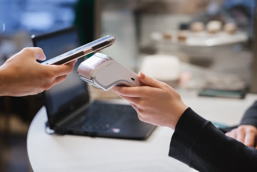 A customer uses his phone to pay through a terminal . Concept of cashless technologies and money transfers photo